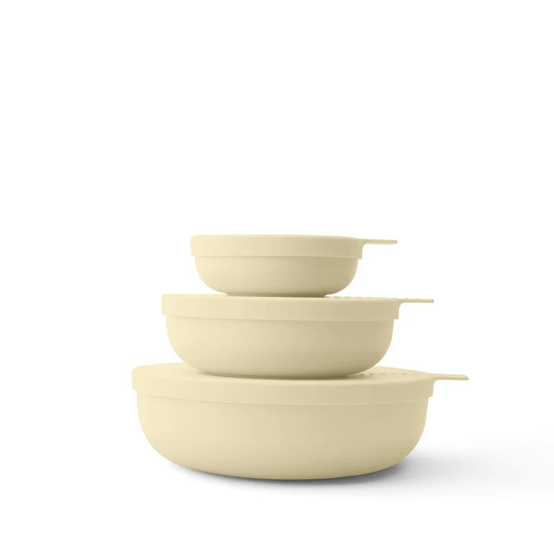 Set of three yellow-colored bowls stacked on a white background