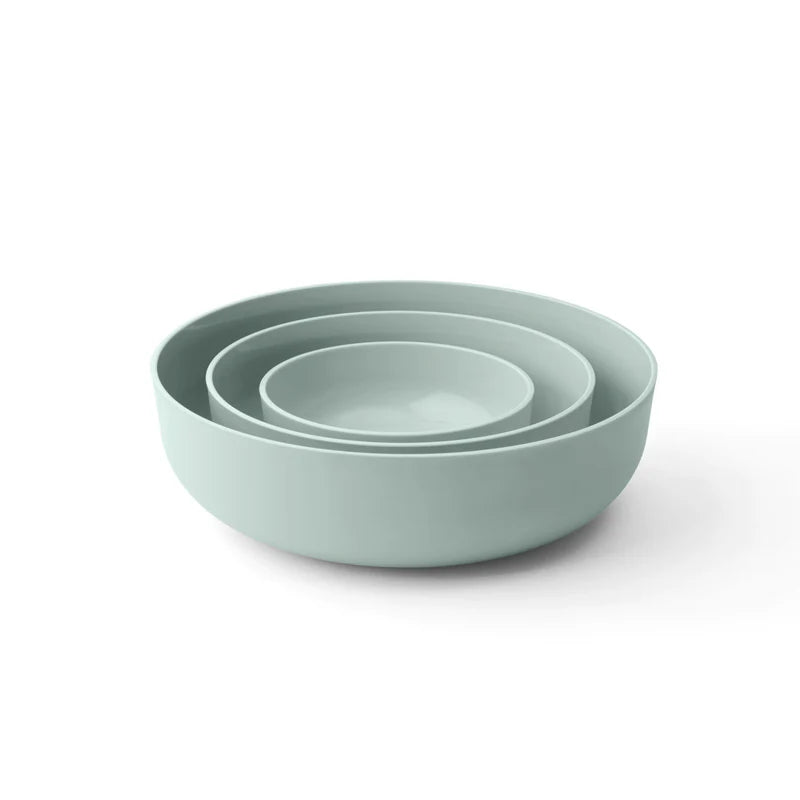 Set of three light green bowls stacked on a white background