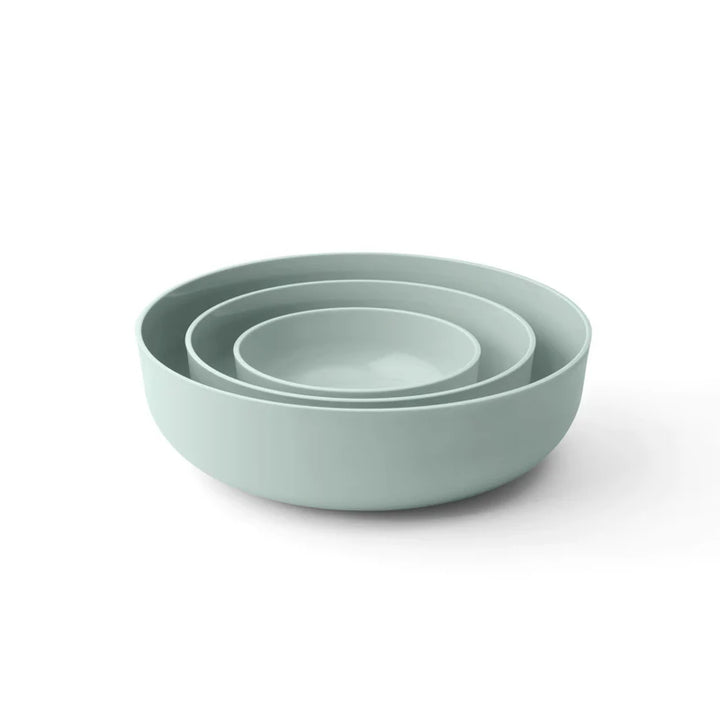 Set of three light green bowls stacked on a white background