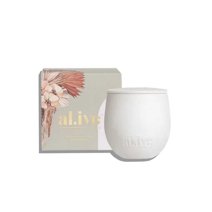 White candle with 'alive' branding next to a decorative box on a white background