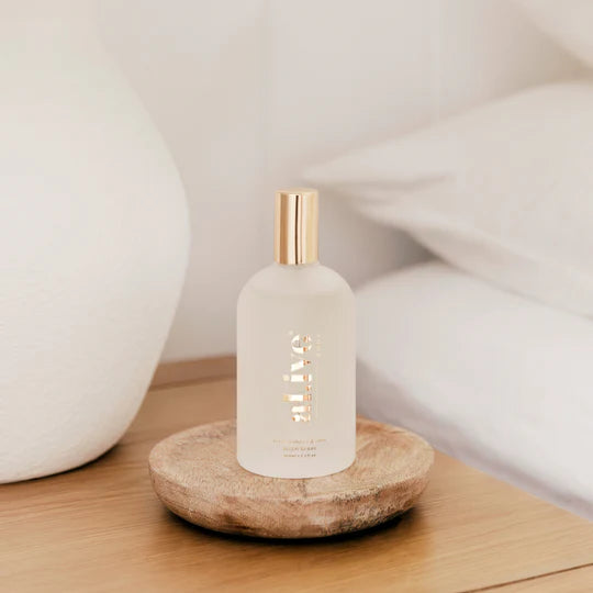 White bottle with gold cap on a wooden surface