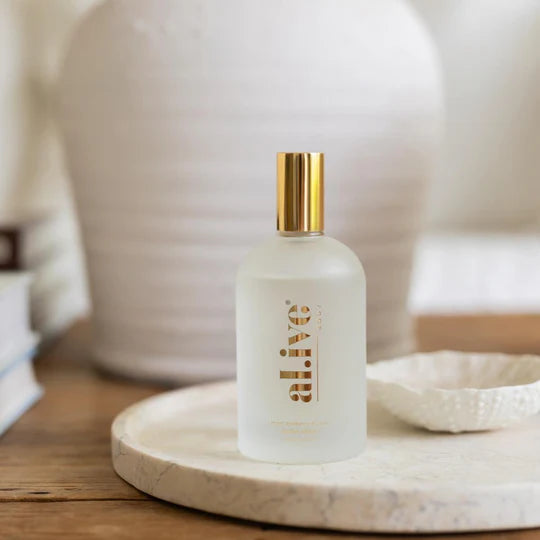 Frosted bottle with gold cap on a marble tray, blurred background