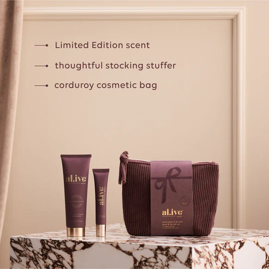 Cosmetic set with 'alive' branding on a marble surface against a beige wall.