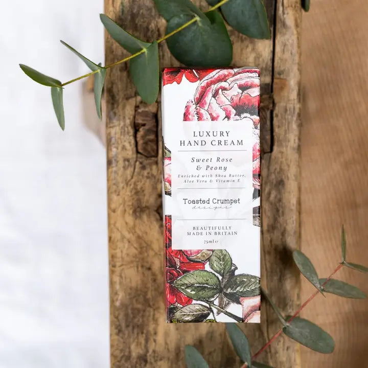 Luxury hand cream packaging with floral design on a wooden background