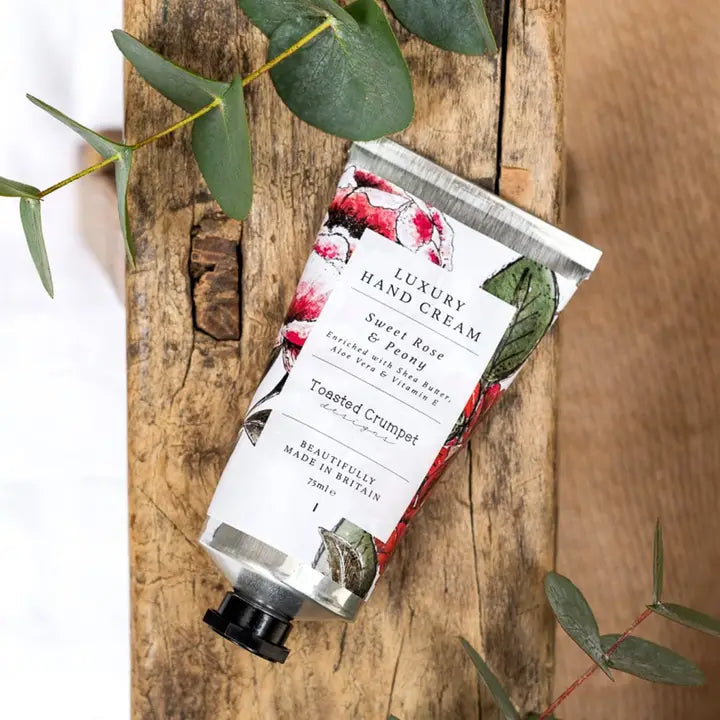 Luxury hand cream with floral packaging on a wooden surface