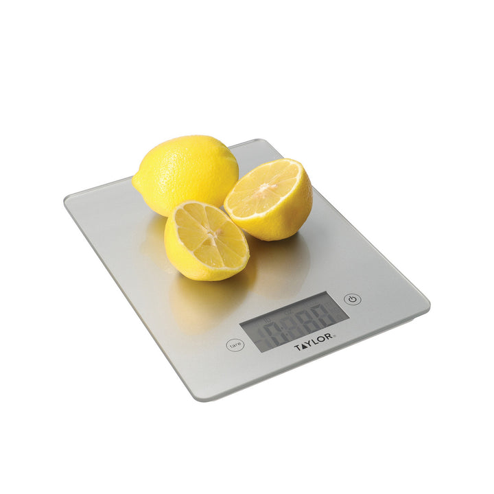 Digital kitchen scale with lemons on a white background