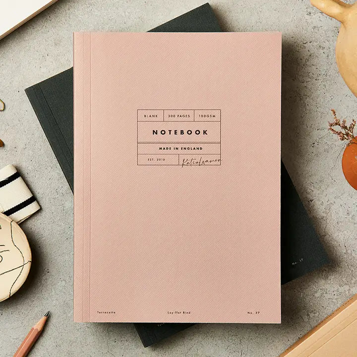 Pink notebook with text on a gray surface