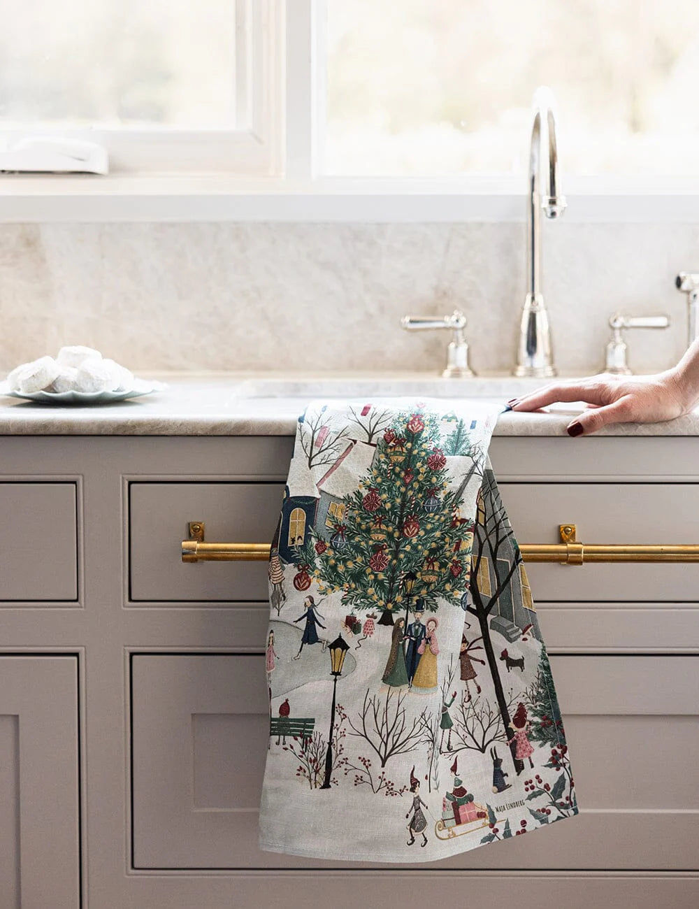 A christmas tea towel with a village scene in a kitchen sink
