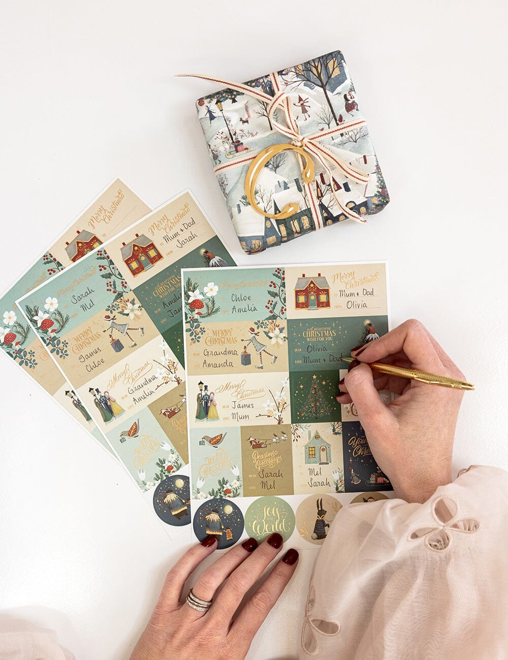 Set of decorative cards and stickers with a person writing on a card.