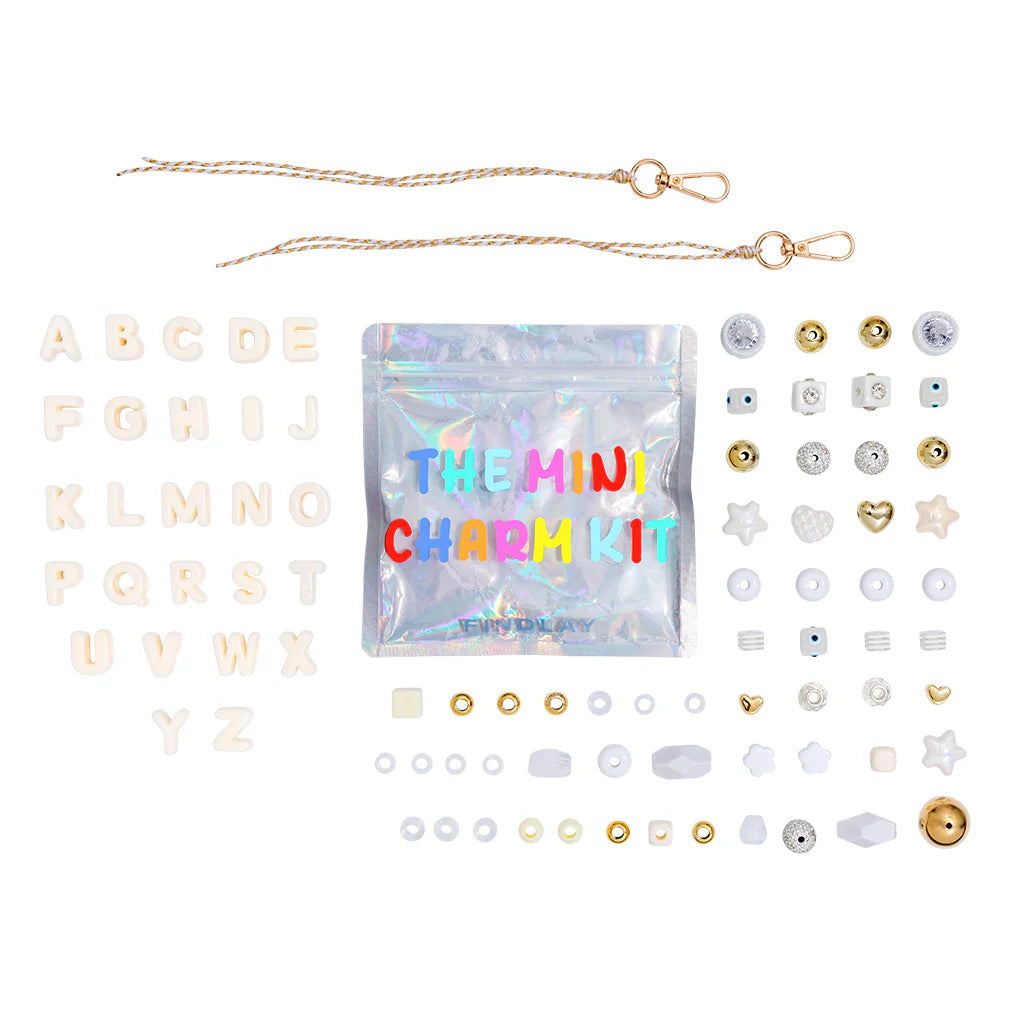 Mini charm kit with various charms and a clear bag labeled 'The Mini Charm Kit' on a white background.