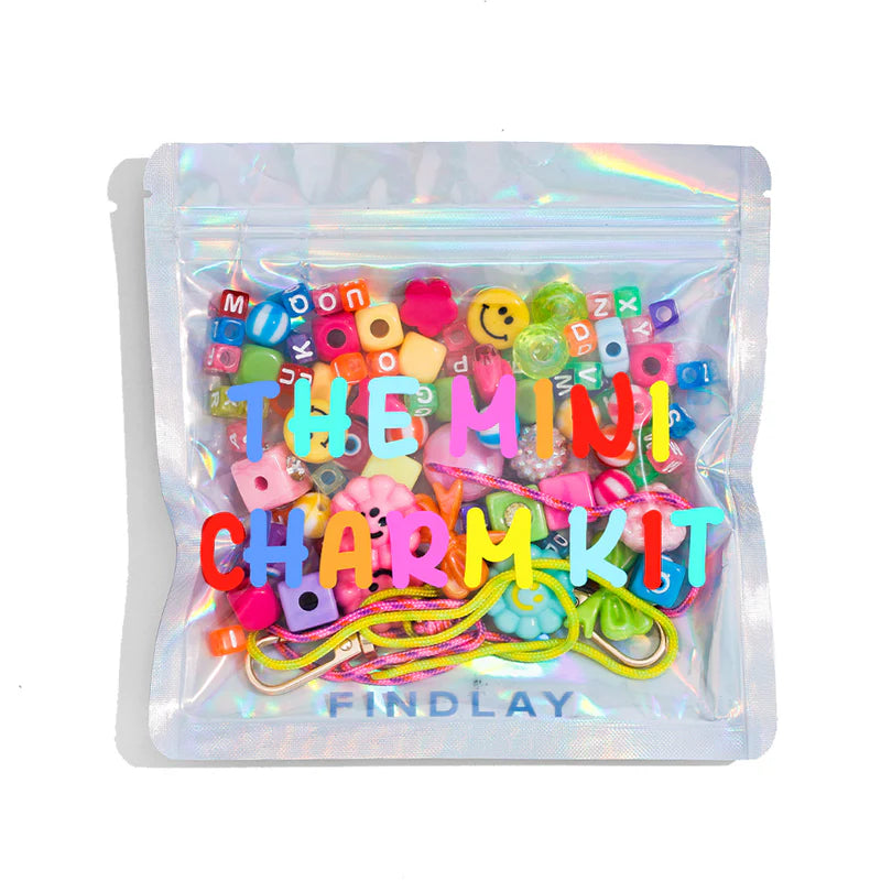 Colorful charm kit with letters and emojis in a clear bag labeled 'THE MINI CHARMS KIT' by FINDLAY on a white background.
