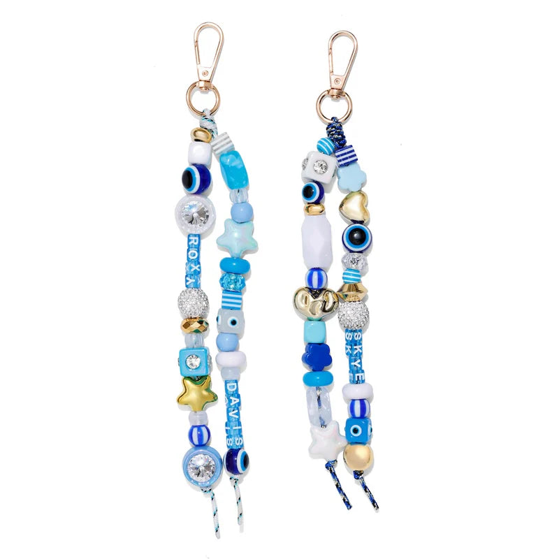 Two decorative keychains with beads and charms on a white background