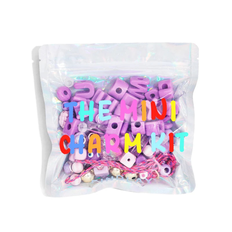 A bag of charms and packaging that sys The Mini charm Kit 