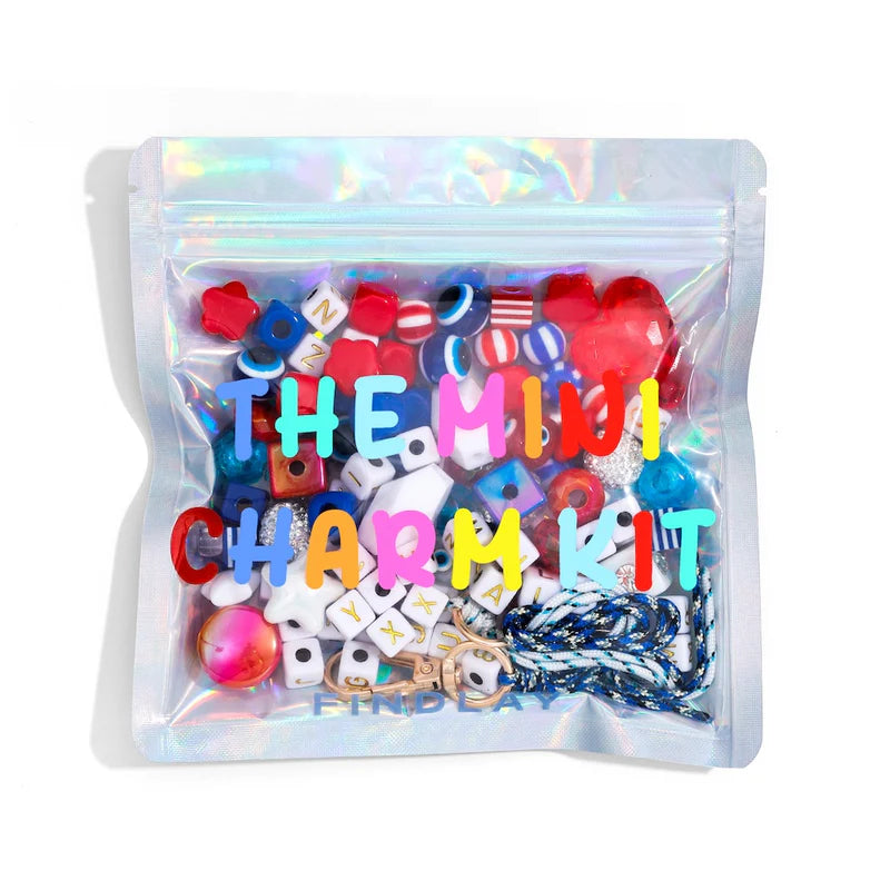 Mini charm kit with colorful charms in a clear bag on a white background