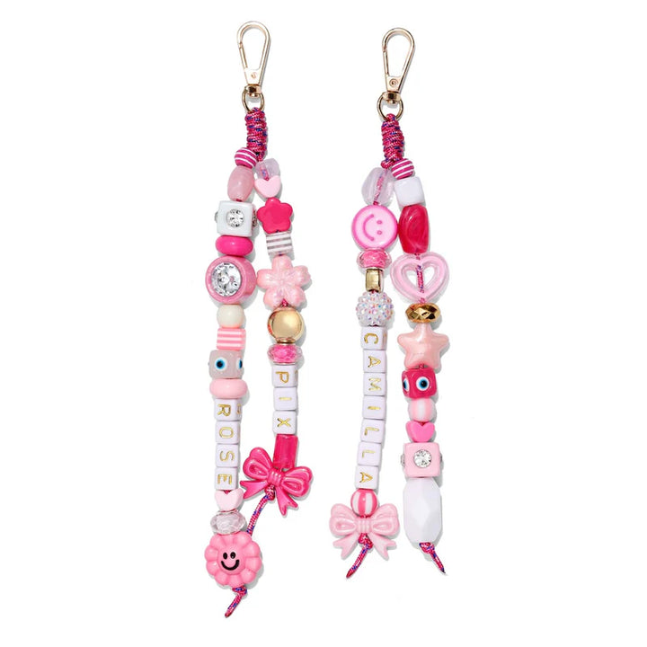 Two pink beaded keychains with decorative elements on a white background