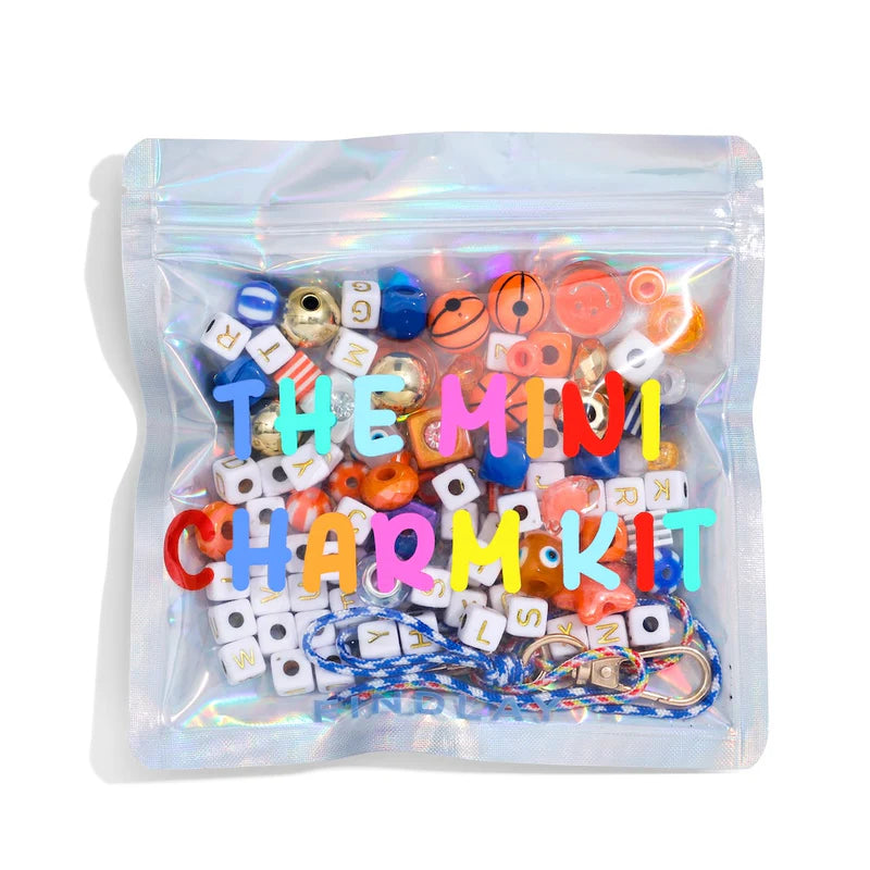 Mini charm kit with colorful beads and letters in a clear packaging on a white background