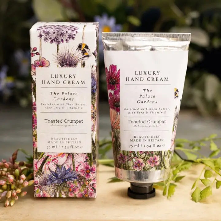 Luxury hand cream packaging with floral design on a wooden surface.