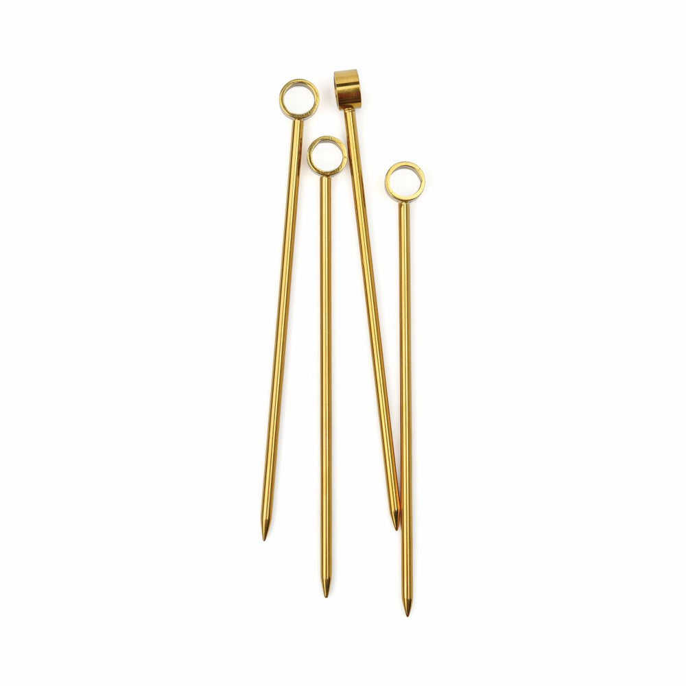 Set of gold-colored cocktail picks on a white background