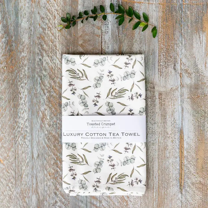 Tea towel with botanical design on a wooden surface