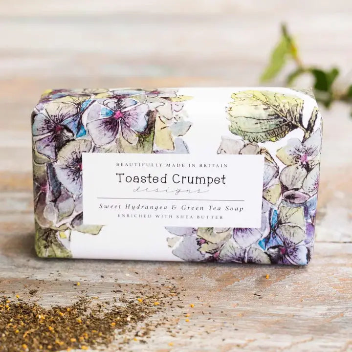 Bar of soap with floral design and 'Toasted Crumpet' branding on a wooden surface.