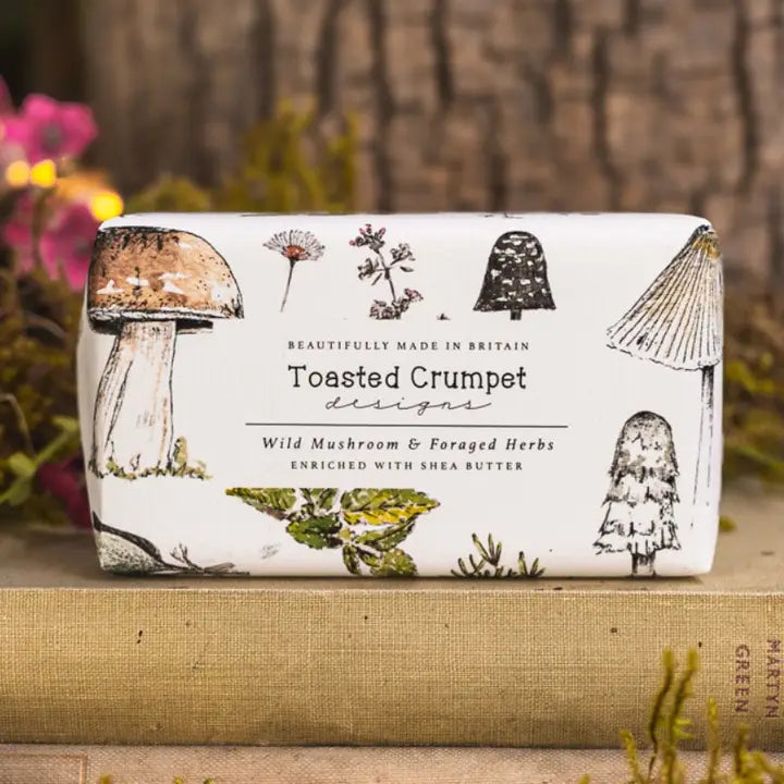 Bar of soap with mushroom design packaging on a wooden surface