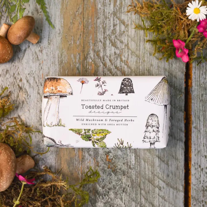 Bar of soap with 'Toasted Crumpet' branding on a wooden surface with natural elements.