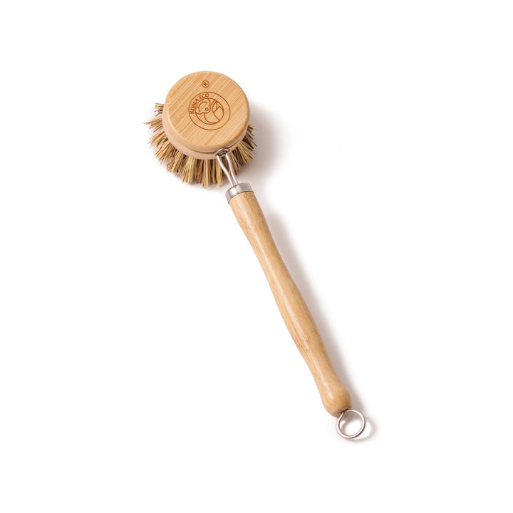Wooden dish brush with a circular bristle head on a white background
