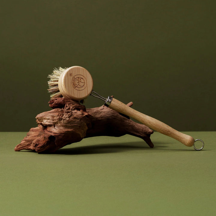 Wooden scrubber and brush on a piece of wood with a green background