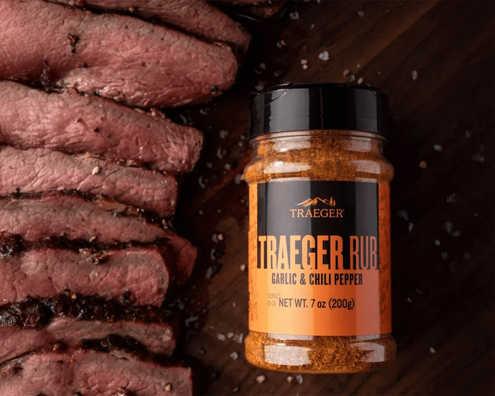 Jar of Traeger Rub with sliced beef on a wooden surface
