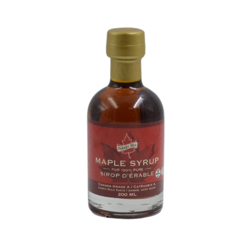 Bottle of maple syrup with a red label on a white background