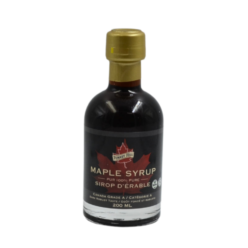 Bottle of maple syrup with a gold cap on a white background