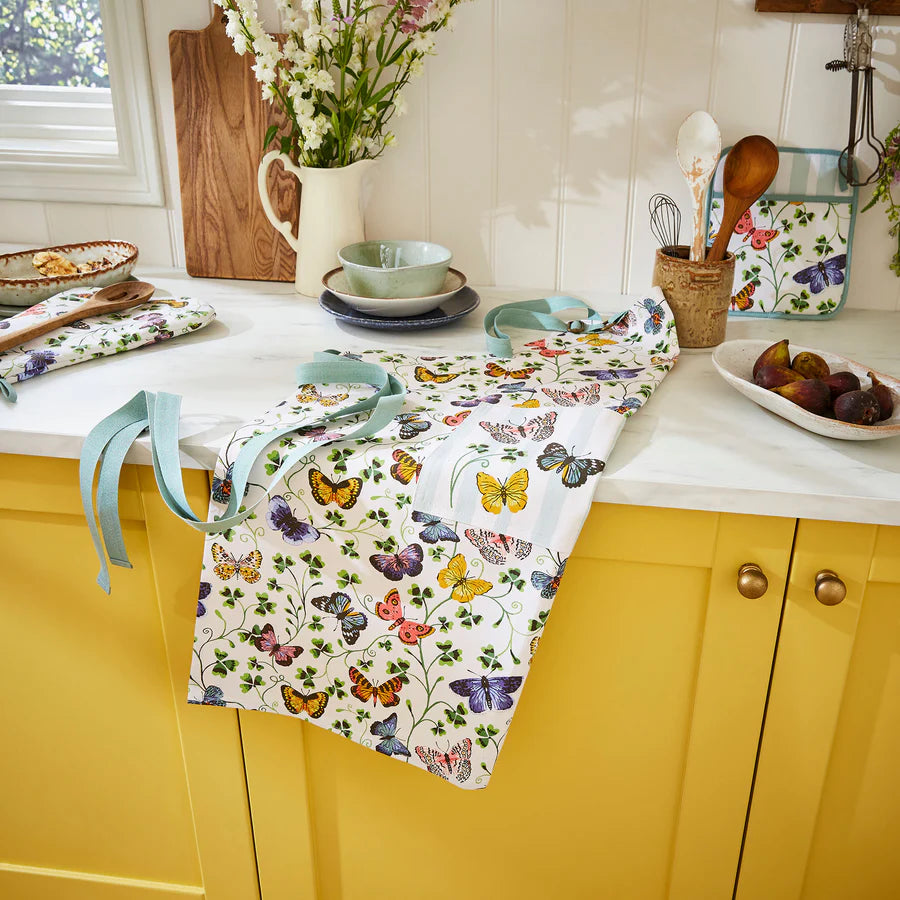 Butterfly-patterned tablecloth on a kitchen counter with yellow cabinets.