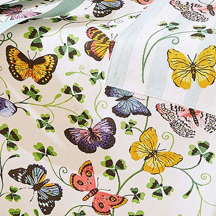 Butterfly-patterned fabric with colorful butterflies and green leaves on a white background