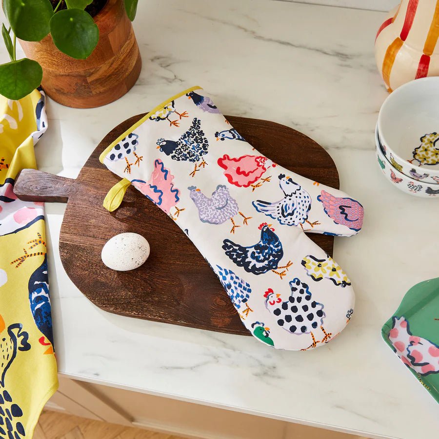 Oven mitt with chicken pattern on a marble surface with kitchen items