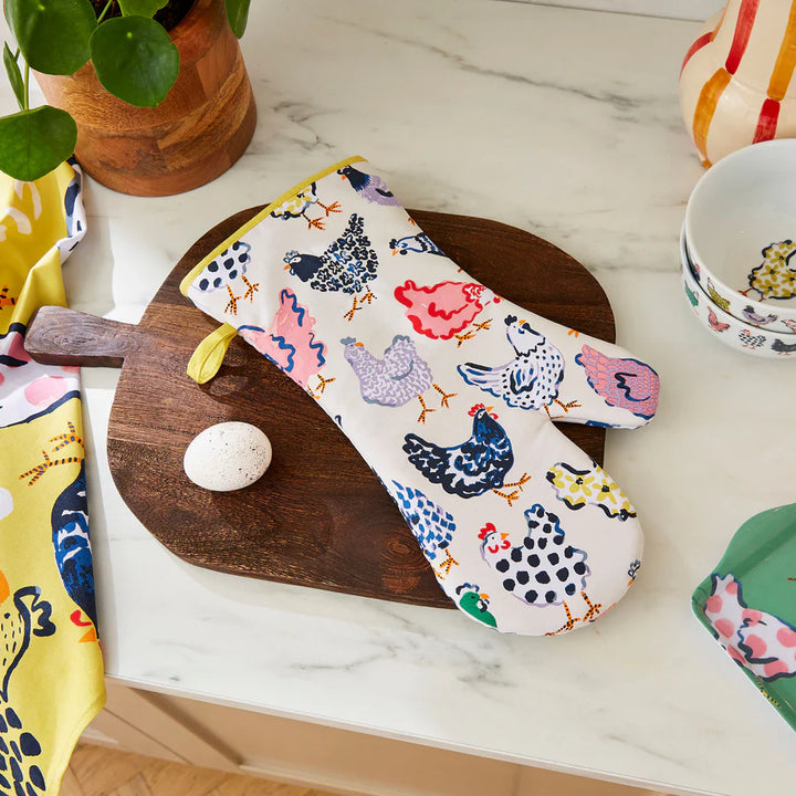 Oven mitt with chicken pattern on a marble surface with kitchen items