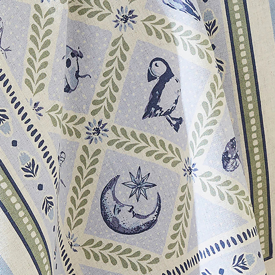 Tea towel with nature-themed design featuring animals, plants, and celestial symbols.