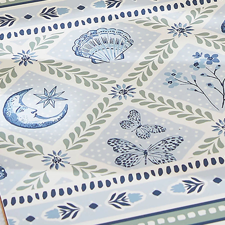 Decorative paper with blue and green floral, butterfly, and moon designs on a light blue background.