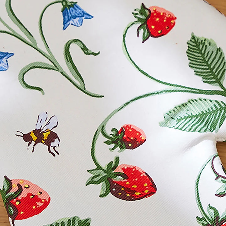 Embroidered fabric with strawberry, bee, and flower pattern on a white background