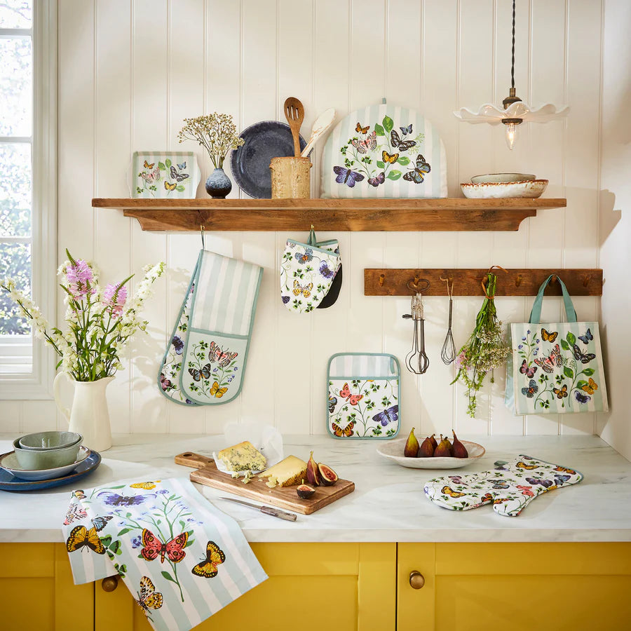 Kitchen scene with floral-themed kitchen towels and accessories on a white countertop.