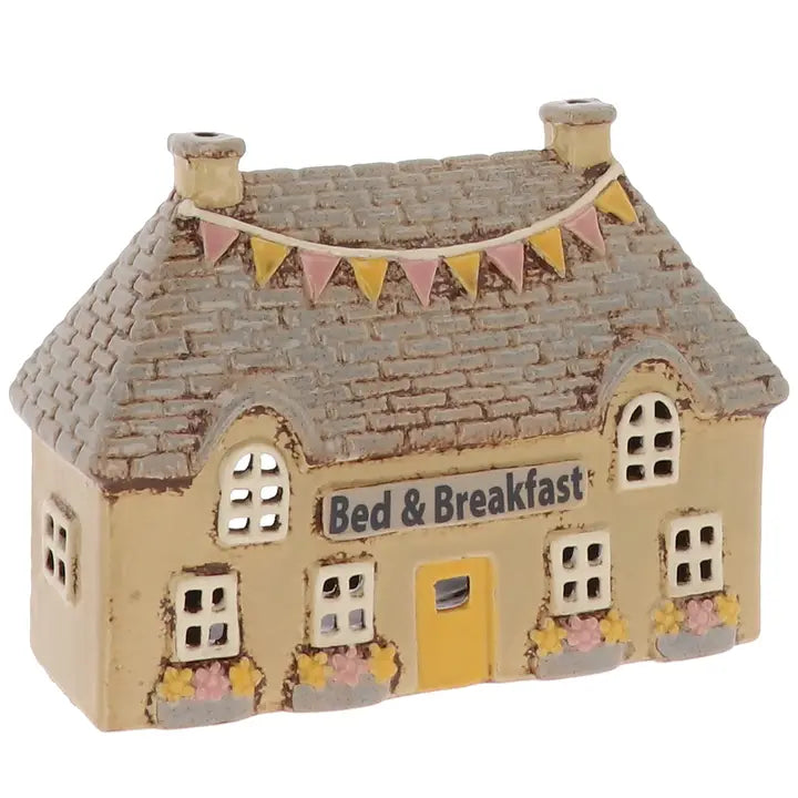 Ceramic tealight holder of a bed and breakfast house with a flag banner on a white background