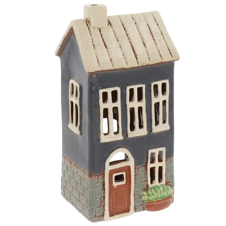 Ceramic house-shaped tealight holder with a white roof on a white background