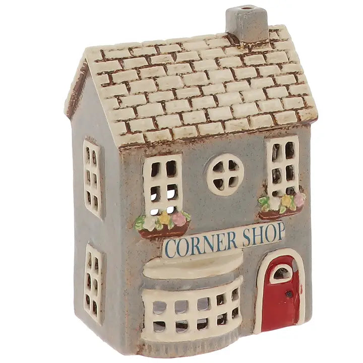 Small tealight holder  of a corner shop  with a red door and white roof on a white background