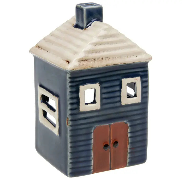 Ceramic house-shaped tealight holder with a white roof on a white background