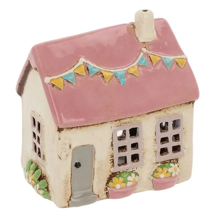 Ceramic house tealight holder with pink roof and bunting on white background