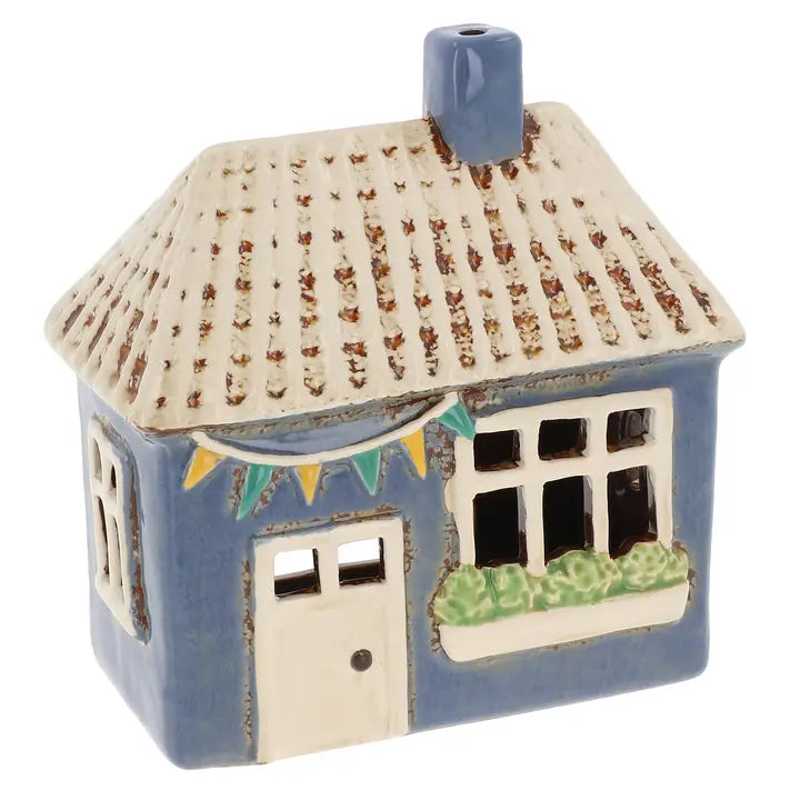 Ceramic house-shaped lantern with a textured roof and small window, on a white background.