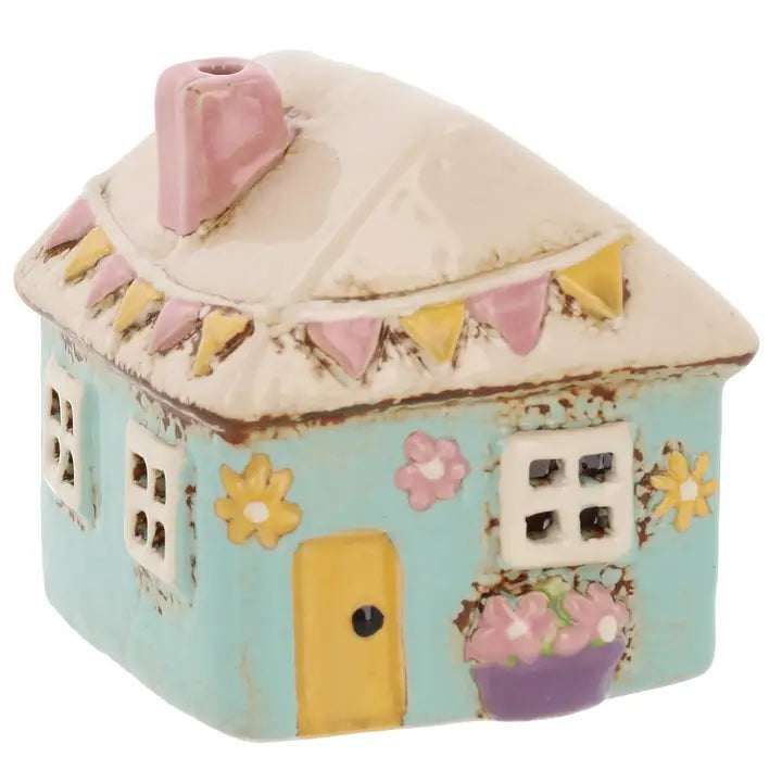 Decorative ceramic tealight holder with a pink roof and colorful details on a white background