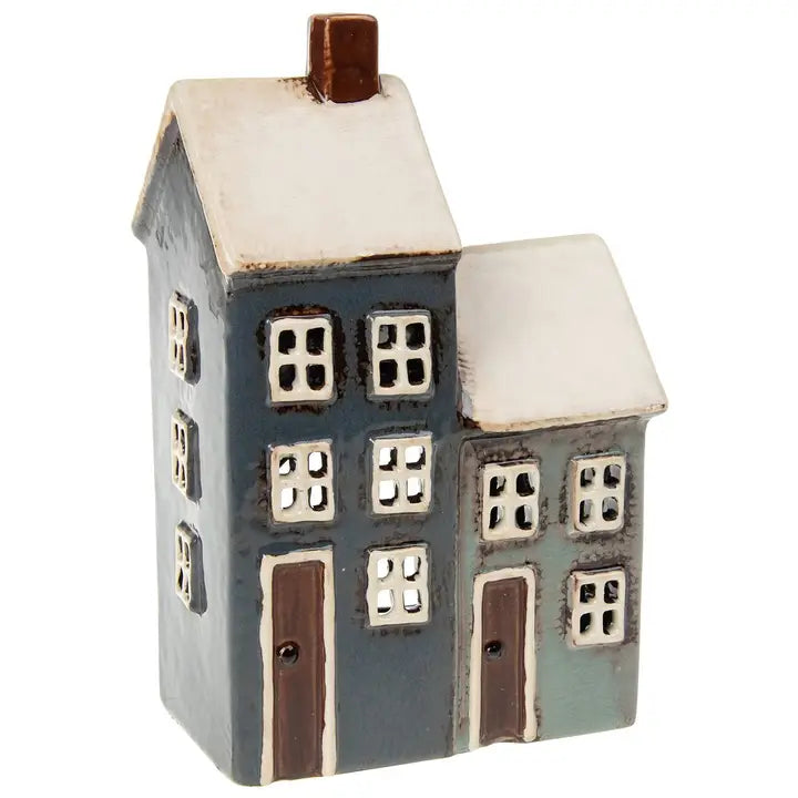 Small ceramic house tealight holder with a white roof on a white background