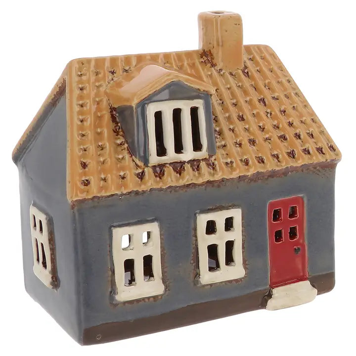 Ceramic house tealight holder with a red door on a white background
