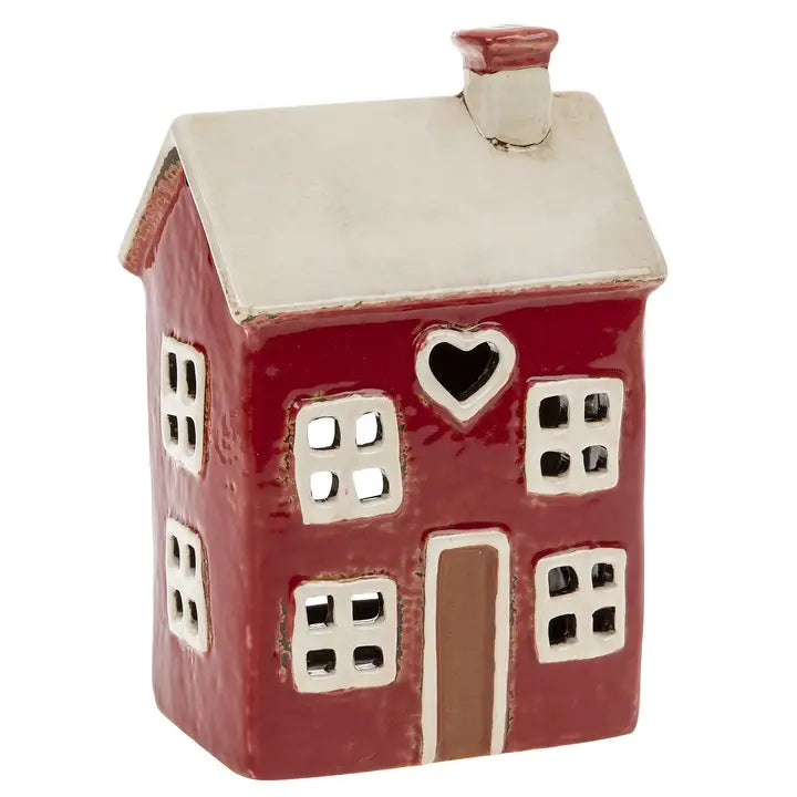 Ceramic house-shaped tealight holder with red body, white roof, and heart window on a white background