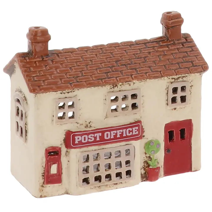 Model of a post office building  tealight holder  with a red sign and door on a white background